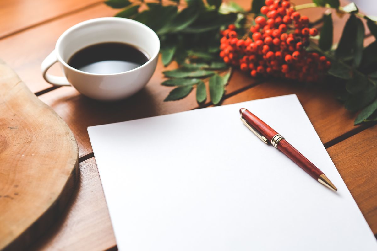 Handwritten lines on a notebook page with a pen resting beside the margin